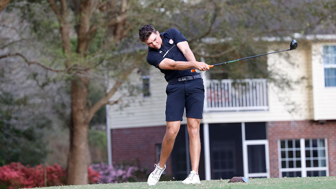 Male student takes golf swing