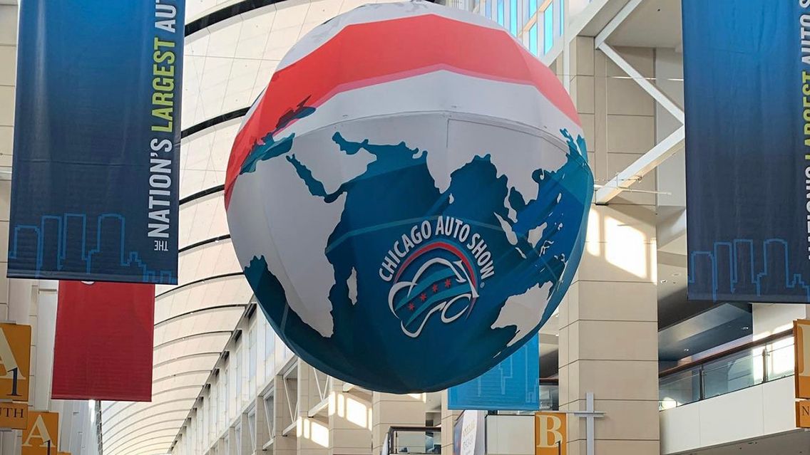 Large Globe with Auto Show logo hanging from ceiling