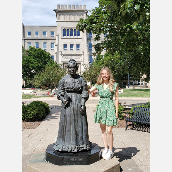 Yvonne Murphy standing next to Lydia Bradley's statue.