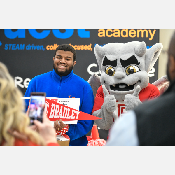 Quest Charter Academy senior Christopher Hudson Jr. (entrepreneurship) received his Hometown Scholar award from Bradley University in a surprise presentation at Quest Charter Academy. He is joined by the Bradley mascot Kaboom!