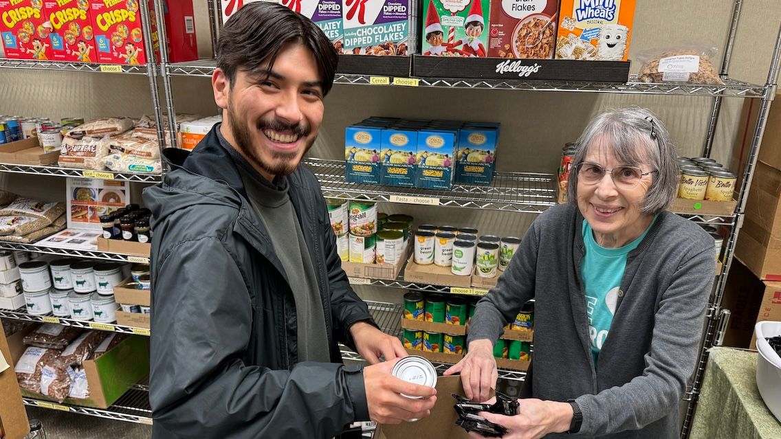PeoriaFresh team member Brian Sida provides aid to a food bank patron